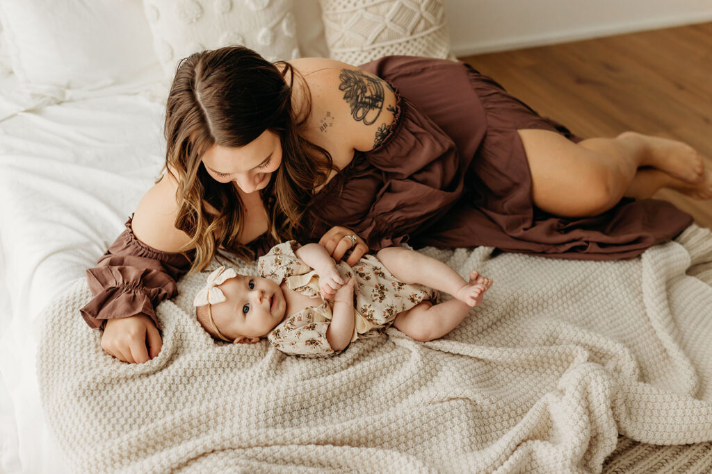 Mom and baby snuggling on bed. Portland Baby Photographer