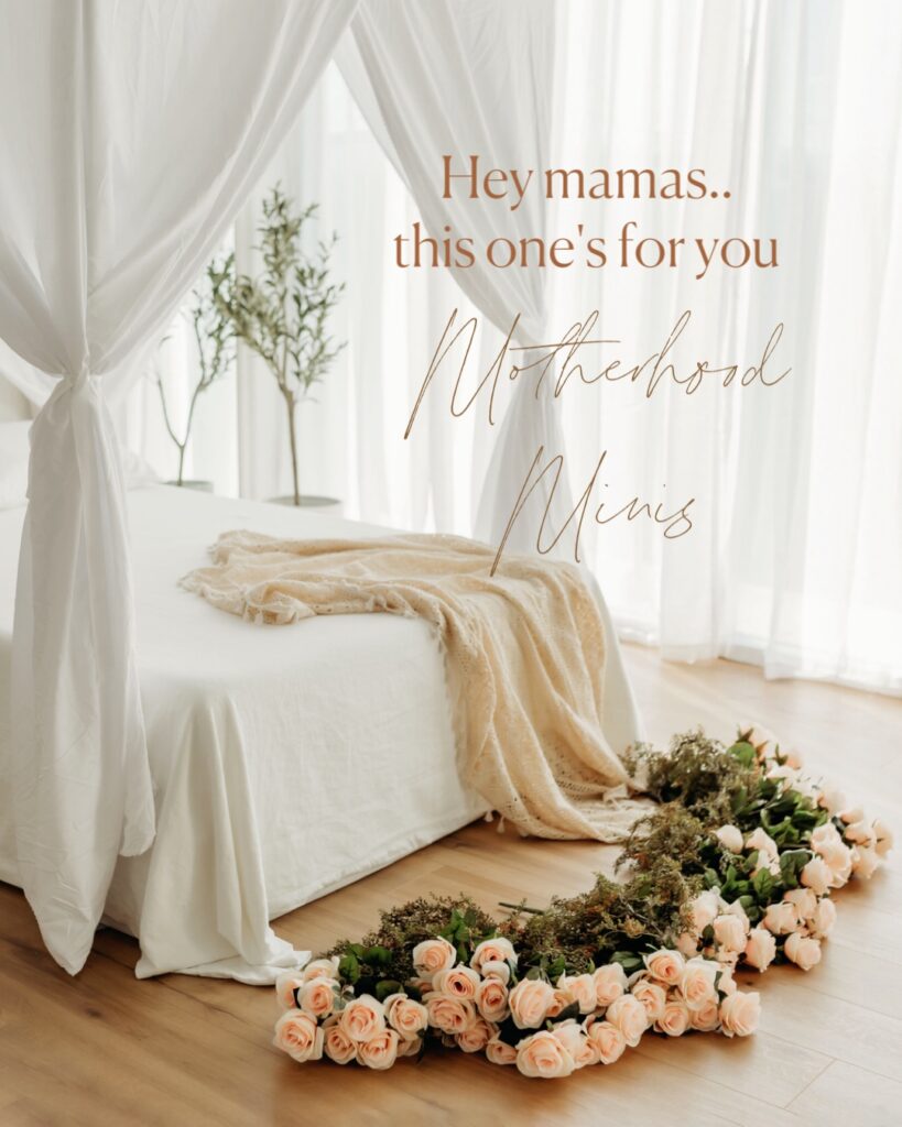 Canopy bed with white linens in a white natural light studio. On the end bed there is a lace cream colored throw blanket. Pink roses line the floor. Image says Hey mamas...this one's for you. Motherhood Minis