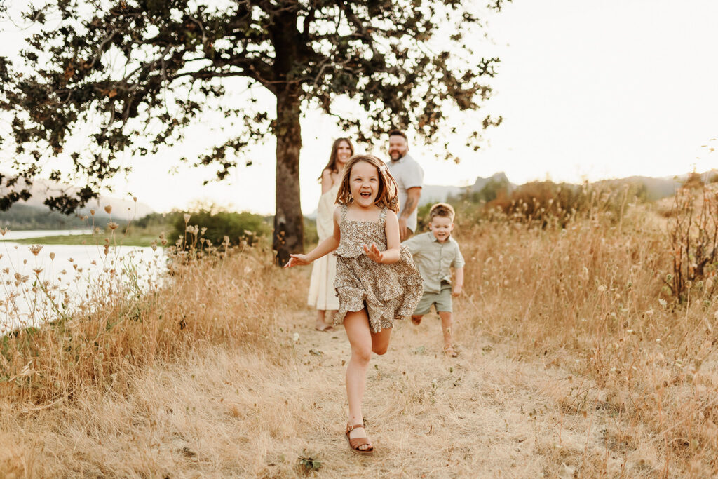 A little girl runs playfully away from her parents and her joy is captured by a Vancouver Washington Photographer who focuses on capturing authentic moments.