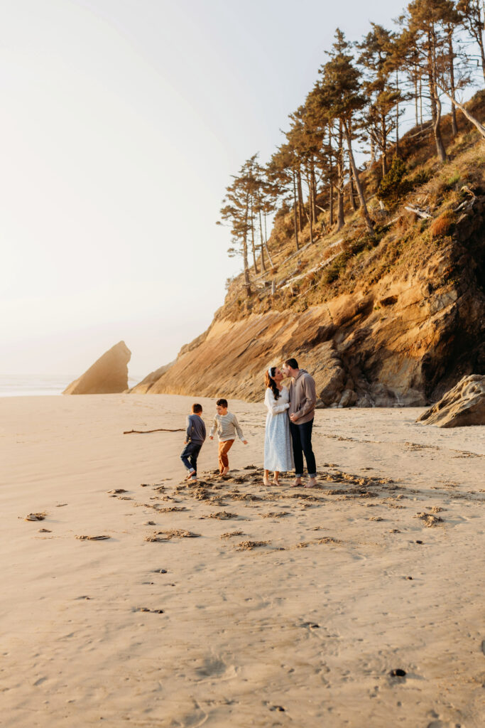 Wide shot of family playing with Oregon Coast cliffs in the background