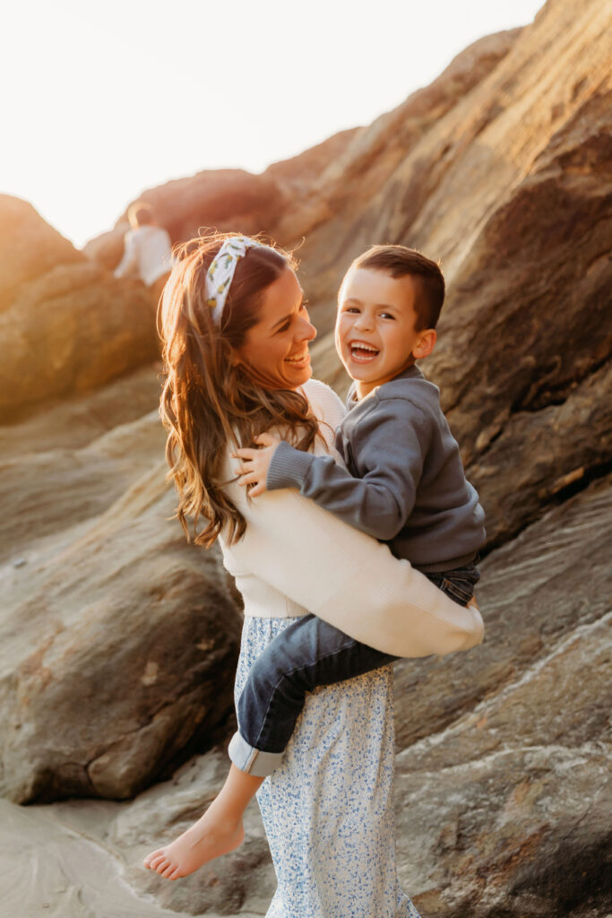 Family snuggles during golden hour session on the Oregon Coast