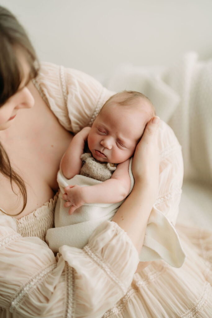 Studio newborn photography session in Vancouver, Washington featuring a wrapped newborn baby sleeping in mom's arms