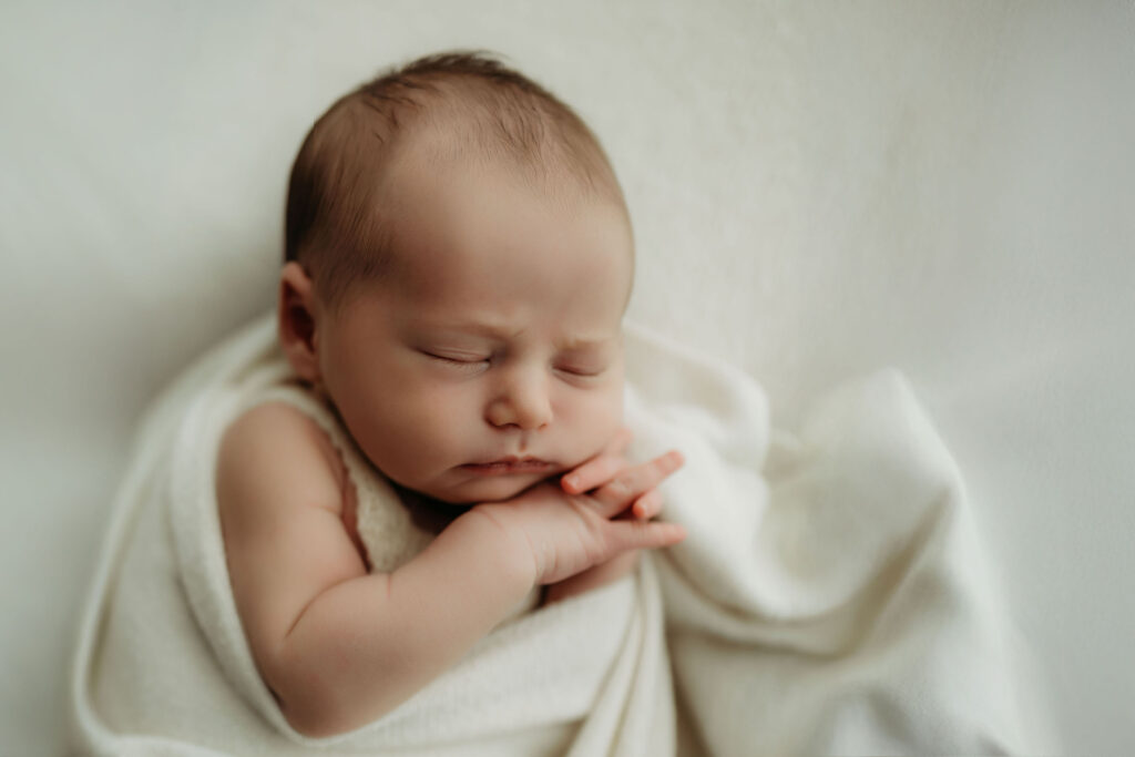 Studio newborn photography session in Vancouver, Washington with newborn baby swaddled and sleeping peacefully