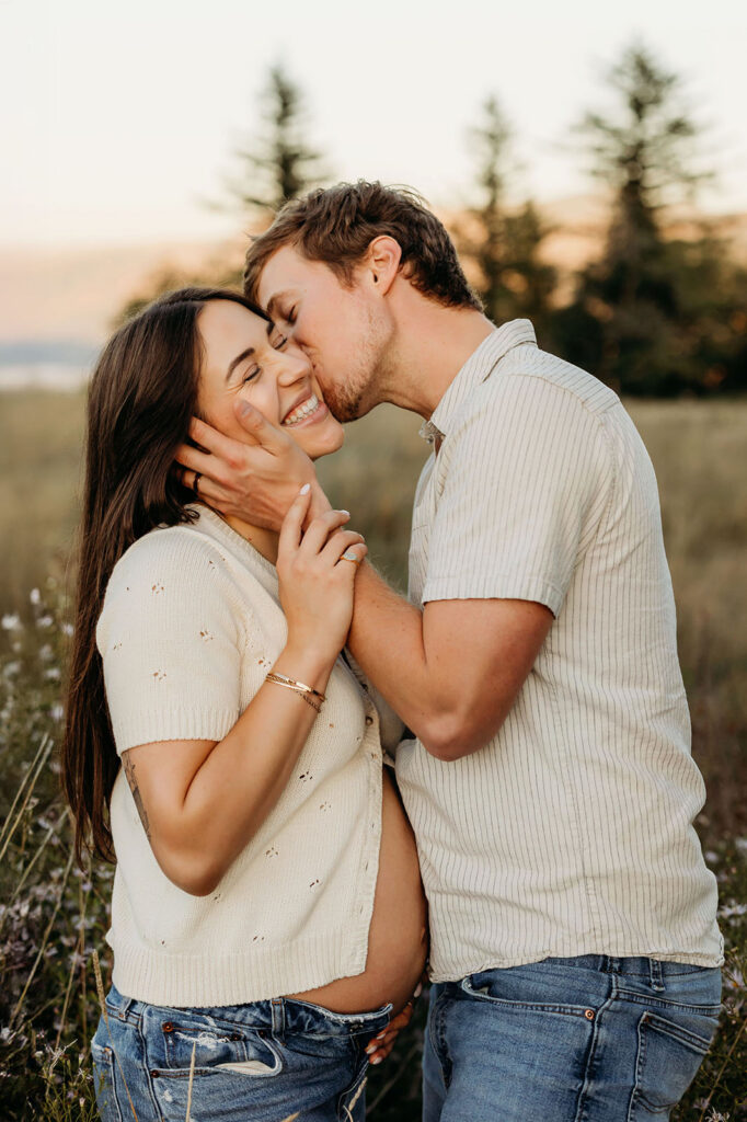 Maternity couple kissing and laughing in Vancouver Washington
