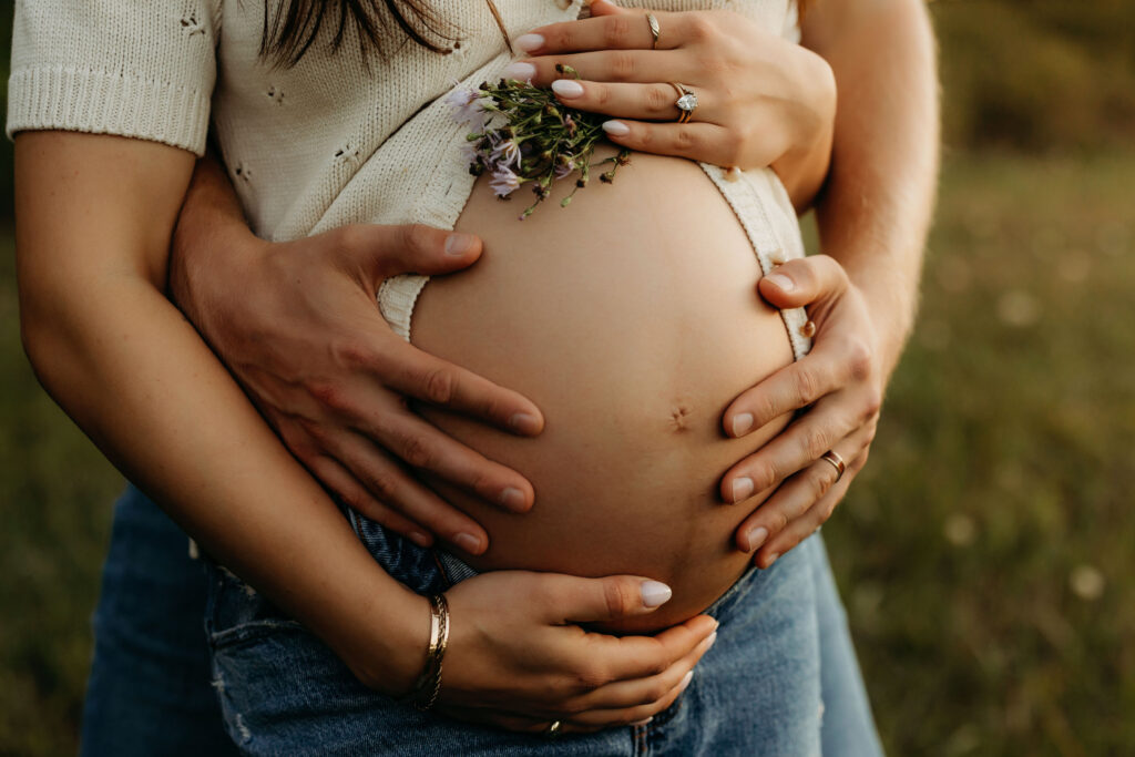 close up of maternity belly with couples hands and close-up of cardigan texture Vancouver Wa